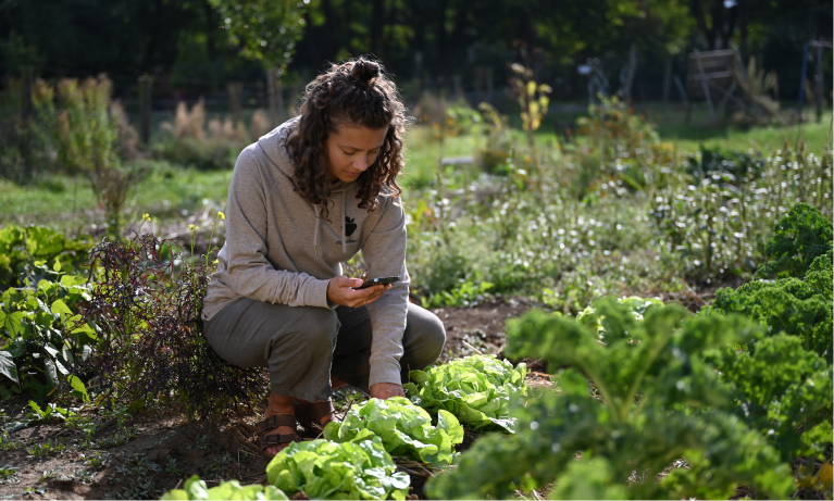 Frau im Garten mit Smartphone
